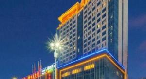 un edificio alto con una luz de la calle delante de él en Golden Phoenix International Hotel, en Xiahuangtang