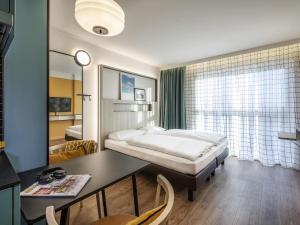a hotel room with a bed and a desk and a bedroom at Aparthotel Adagio access Hamburg in Hamburg