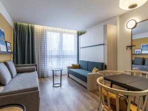 a living room with a couch and a table at Aparthotel Adagio access Hamburg in Hamburg