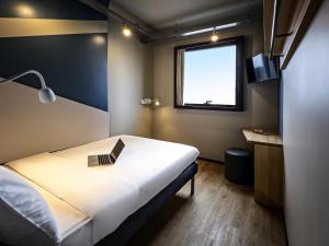 a room with a bed with a laptop on it at Ibis Budget Balneario Camboriu in Balneário Camboriú