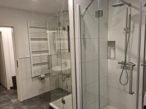 a bathroom with a glass shower with a sink at Work & Stay in Rodenbach in Rodenbach