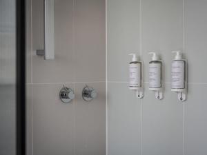 a bathroom with two shampoo bottles on the wall at Elkonin Tel Aviv - MGallery Hotel Collection in Tel Aviv +109 photos