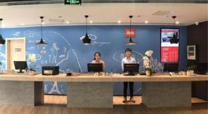 a group of people standing at a large desk at Ibis Xinzhou Qiyi RD in Xinzhou Zhan