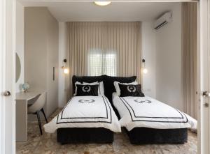 a bedroom with two beds and a desk at The charm of Jerusalem in Jerusalem