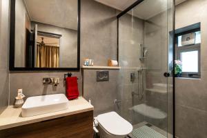 a bathroom with a shower and a sink and a toilet at StayVista at Ember Home with Balcony, Meals Available in Mussoorie