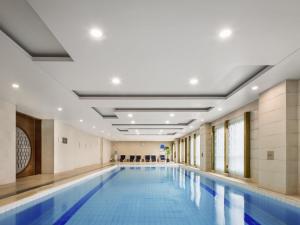 a large swimming pool in a building with a swimming poolvisor at Swissôtel Shenyang in Shenyang