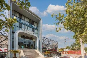 Un gran edificio con escaleras al frente. en Xana Lite Beijing Liangxiang University City Branch, en Wangzhuang