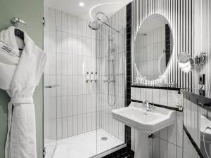a bathroom with a shower and a sink and a mirror at The 1932 Hotel & Spa Cap d'Antibes - MGallery Collection in Juan-les-Pins