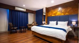 a hotel room with a large bed and a chair at Vince Sakon in Sakon Nakhon +46 photos