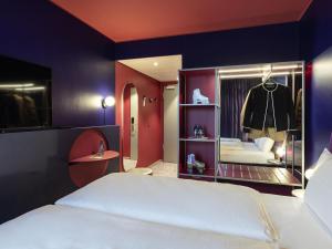 ミュンヘンにあるibis Styles Muenchen Perlachの白いベッドと鏡のある寝室