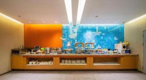a kitchen with a counter and a blue tile wall at Home Inn Neo Leshan Central Food Street in Leshan