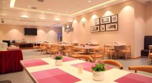 a restaurant with tables and chairs and a tv at Yitel Shanghai Hongqiao Railway Station National Convention and Exhibition Center in Fangjiayao