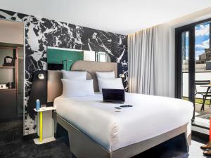 a bedroom with a bed with a laptop on it at Tribe Paris La Defense Esplanade in Courbevoie