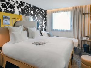 een hotelkamer met twee bedden en een raam bij Tribe Paris La Defense Esplanade in Courbevoie