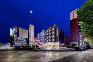 un grupo de edificios en una ciudad por la noche en James Joyce Coffetel Zhengzhou Aquarium Chenyan Flower, en Zhengzhou