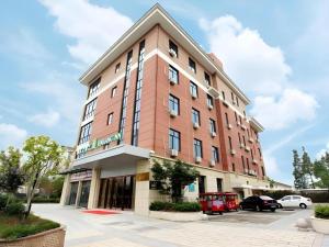 een groot rood gebouw met een parkeerplaats bij Jinjiang Inn Style Wuxi Yuqihu Xi Road in Wuxi