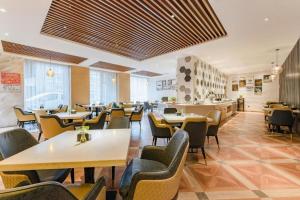 a restaurant with tables and chairs in a room at Jinjiang Metropolo Zhengzhou Songshan Road in Zhengzhou