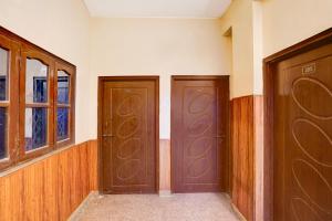 two brown doors in a room with a window at Super Hotel O Dehradun City Centre in Dehradun