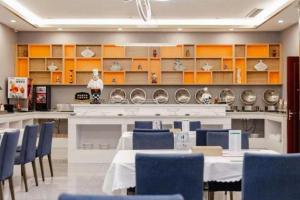 a dining room with a table and blue chairs at Vienna Hotel Tongliao Ke'erqin in Tongliao