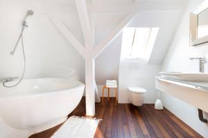 a bathroom with a white tub and a sink at Les Appartements Saint Nicolas in Colmar