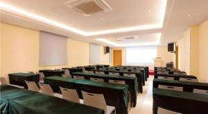 an empty lecture room with green tables and chairs at JTOUR Inn Guigang Life Port High-speed Railway Station in Guigang