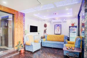 a living room with two couches and a tv at Super Townhouse Lighthouse Beach Formerly Neel Sagar in Puri