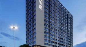 a tall building with a sign on the side of it at Echarm Hotel Nanning Chaoyang Square River View in Nanning