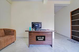 KhāpriにあるSuper Hotel O CRPF Crossway Formerly V7 Inn Service Apartmentのソファ付きの部屋のテーブルにテレビが備わります。