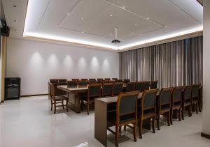 a conference room with a long table and chairs at Borrman Hotel Qianjiang High-speed Railway Station Lobster City in Sanjiang