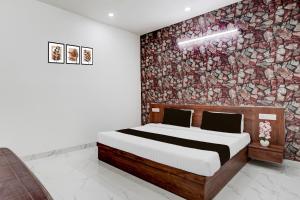 a bedroom with a bed and a wall of flowers at Collection O Palwal-Aligarh Crossway Formerly Hotel Kadamb in Palwal
