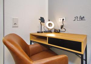a desk with a chair next to a desk with a mirror at Suite nähe Klinik, Theme, Parkplatz in Bad Lippspringe +14 photos