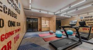 a room with a gym with a treadmill and weights at Borrman Hotel Qianjiang High-speed Railway Station Lobster City in Sanjiang