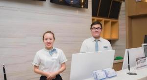 een man en een vrouw die voor een bureau staan bij City Comfort Inn Hechi Tian'E Bus Terminal in Nandan