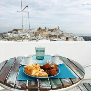 una mesa con un plato de pan y tazas de café en Dafne en Ostuni