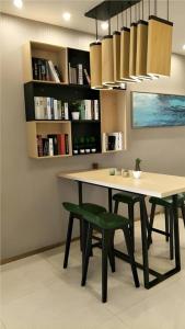 a table and two green chairs in a room at City Comfort Inn Jiangxia Wuchang University of Technology in Wuhan