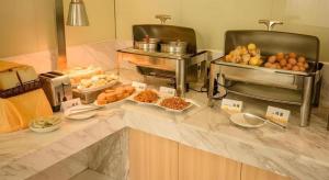 ein Buffet mit verschiedenen Speisen auf der Theke in der Unterkunft City Comfort Inn Huizhou Danshui High-speed Railway Huiyang Station in Huizhou