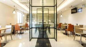 un restaurante con mesas y sillas y una puerta de cristal en City Comfort Inn Nanning Wuming, en Wuming