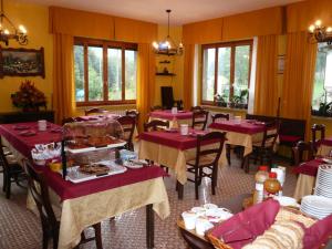 ein Restaurant mit Tischen, Stühlen und roten Tischdecken in der Unterkunft Albergo Panice in Limone Piemonte