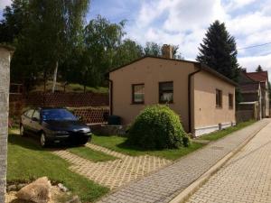 a car parked in front of a small house at Ferienhaus Obschütz in Weißenfels