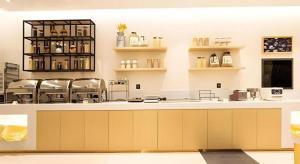 a large kitchen with a counter and shelves at City Comfort Inn Nanning Jianzheng Road Food Street in Nanning