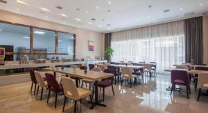 a restaurant with tables and chairs in a room at Lavande Hotels· Suizhou Wenfeng in Suizhou