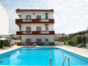 a building with a swimming pool in front of a building at Haris Apartments in Kokkini Khanion