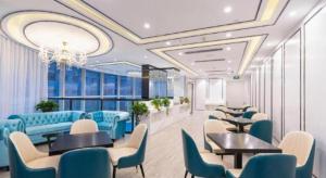 a restaurant with blue chairs and tables in a room at Xana Hotelle· Wulumuqi High Speed Railway Station Baonengcheng in Ürümqi