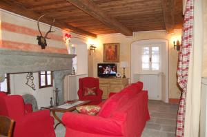 a living room with a red couch and a fireplace at Le Primule in Piedilago