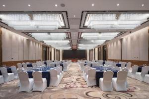 Un gran salón de banquetes con mesas y sillas blancas. en Xincheng hotel, en Zunyi 238 fotos más