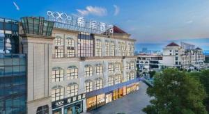 een groot gebouw met een bord erop bij Xana Hotelle Luzhou High-Speed Railway Station Trading Market Passenger Terminal in Luzhou