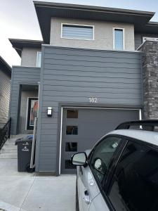 un coche aparcado frente a un garaje en Delly place, en Winnipeg