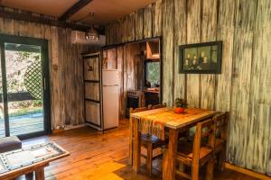 a dining room with a table and a refrigerator at Cabañas en el Bosque a 5 minutos del mar - Estancia CH in Punta del Este