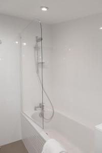 a bathroom with a glass shower with a sink at Grand Théâtre Bright Apartment in Bordeaux