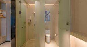 a bathroom with a toilet and a glass shower at Echarm Hotel Nanning Wuxiang Headquarters Base in Nanning
